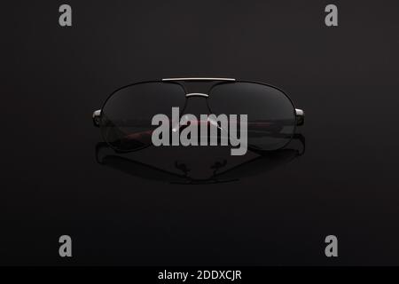 occhiali da aviatore neri di tendenza su sfondo scuro. Foto Stock