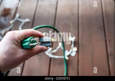 Uso tipico di un adattatore di alimentazione elettrica a 3 poli da un cavo di alimentazione dotato di messa a terra a un cavo a 2 poli senza collegamento messa a terra Foto Stock