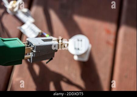 Uso tipico di un adattatore di alimentazione elettrica a 3 poli da un cavo di alimentazione dotato di messa a terra a un cavo a 2 poli senza collegamento messa a terra Foto Stock