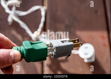 Uso tipico di un adattatore di alimentazione elettrica a 3 poli da un cavo di alimentazione dotato di messa a terra a un cavo a 2 poli senza collegamento messa a terra Foto Stock