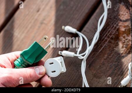 Uso tipico di un adattatore di alimentazione elettrica a 3 poli da un cavo di alimentazione dotato di messa a terra a un cavo a 2 poli senza collegamento messa a terra Foto Stock