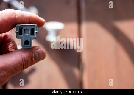 Uso tipico di un adattatore di alimentazione elettrica a 3 poli da un cavo di alimentazione dotato di messa a terra a un cavo a 2 poli senza collegamento messa a terra Foto Stock