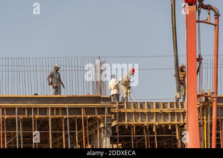 "RAK, RAK, Emirati Arabi Uniti - 11/21/2020: Camion di pomper idrallici di cemento o cemento e lavoratori che versano calcestruzzo in una casa residenziale. IND Foto Stock
