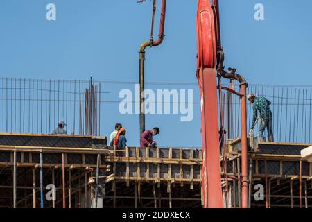 "RAK, RAK, Emirati Arabi Uniti - 11/21/2020: Camion di pomper idrallici di cemento o cemento e lavoratori che versano calcestruzzo in una casa residenziale. IND Foto Stock