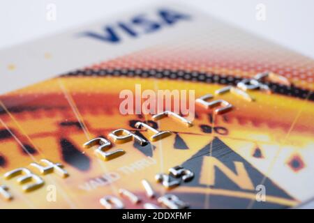 Primo piano di una carta di credito Visa su sfondo bianco. Concentrarsi su una parte del numero di account Foto Stock