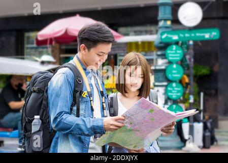 Giovane coppia zaino in spalla turista asiatico alla ricerca di direzione alla mappa mentre si viaggia in Khao San Road, Bangkok, Thailandia Foto Stock