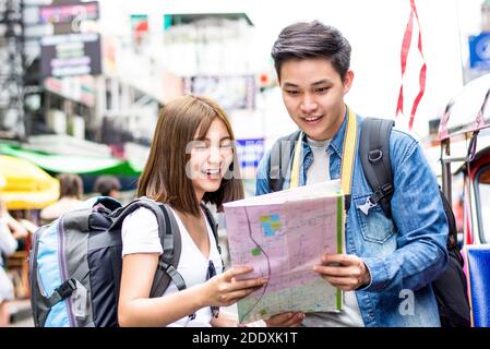 Giovane coppia zaino in spalla turista asiatico alla ricerca di direzione alla mappa mentre si viaggia in Khao San Road, Bangkok, Thailandia Foto Stock