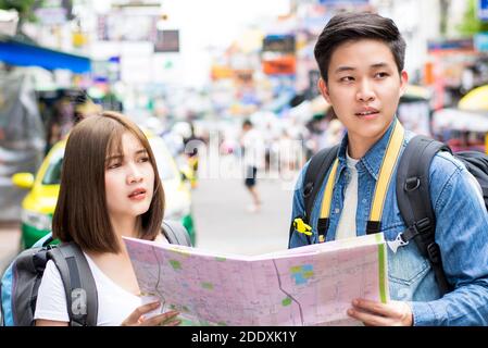 Giovane coppia zaino in spalla turista asiatico sempre perso e in cerca di direzione durante il viaggio a Khao San Road, Bangkok, Thailandia Foto Stock