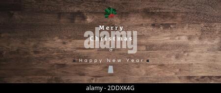 Buon Natale e Felice anno nuovo testo su sfondo tavola in legno, vista dall'alto banner panoramico Foto Stock