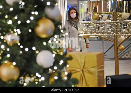 Quadro tematico i prigionieri nella pandemia del coronavirus il 26 novembre 2020. Una giovane donna con maschera facciale, maschera si trova dietro un Weihaftertsbaum in un centro commerciale, centro commerciale. Pandemia, blocco, arresto, valore di incidenza. MODELLO RILASCIATO! | utilizzo in tutto il mondo Foto Stock