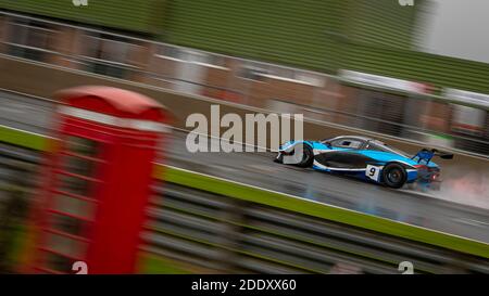 Una panoramica di una vettura da corsa mentre si guida su una pista. Foto Stock