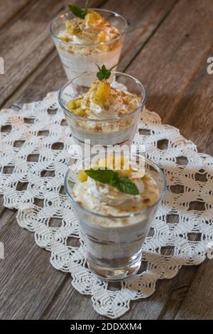 Mousse di mango in tazza di vetro con menta su sfondo di legno Foto Stock
