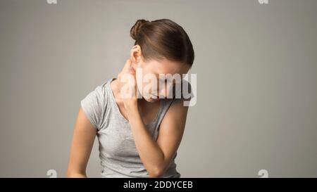 Donna stanca che sente dolore, massaggiando i muscoli tesi Foto Stock