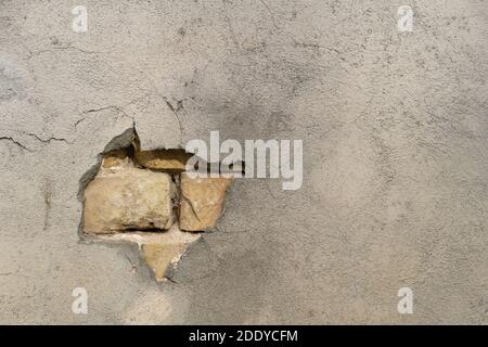 la struttura del rivestimento dell'edificio con un pezzo che cade fuori con uno spazio su un muro di mattoni sbriciolato. Sfondo di muro di mattoni modello Foto Stock