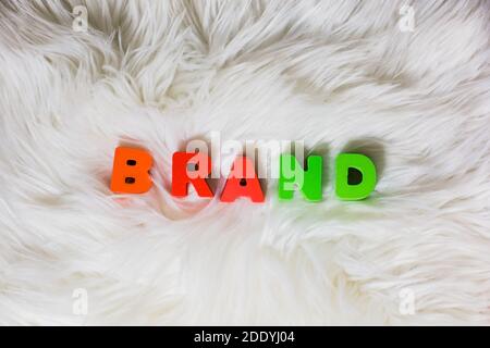 Ortografia del marchio di parola da lettere abc colorate in legno fluffly, faux fur bianco sfondo, moda, industrie dei social media, concetto di stile Foto Stock