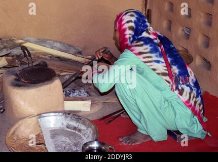 Indiano Village donna, soffiando alla fornace o stufa di argilla per aumentare la sua fiamma. La stufa Clya è anche conosciuta come Chulha in lingua hindi Foto Stock