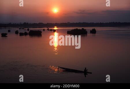 31.01.2010, Muang Khong, Laos, Asia - guardando dall'isola di Don Det su una canoa di legno che si staglia contro l'alba sul fiume Mekong. Foto Stock