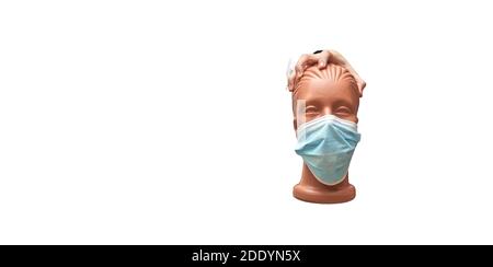 la mano tiene un manichino con una maschera medica su uno sfondo bianco isolato, banner, spazio per la copia Foto Stock