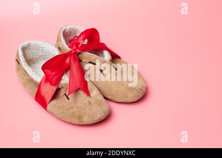 pantofole invernali con pelliccia in un nastro rosso, su sfondo blu, striscione, spazio per la copia, mock-up Foto Stock