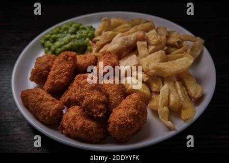 Scampi, patatine e piselli, classico ristorante britannico di pesce e patatine e take-away Foto Stock