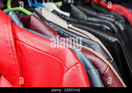 giacche in pelle appese su un appendiabiti nel mercato cittadino all'aperto il giorno d'autunno Foto Stock