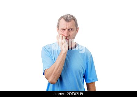 Premuroso sottolineato l'uomo medio invecchiato mordendo le unghie delle dita, gesto nervoso, isolato su sfondo bianco. Ansioso lavoro medio anziano lavoratore desper Foto Stock