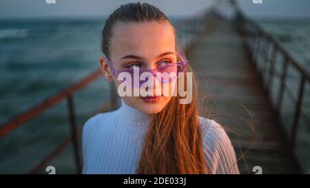 Affascinante giovane donna guarda al tramonto in mare Foto Stock