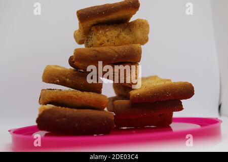 Pila di toast asciutti sulla piastra di plastica. Primo piano Affianca di fette di pane tostato. Tostare la focaccia su sfondo bianco. Foto Stock