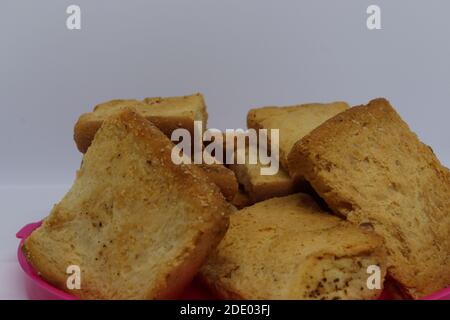 Stack di melba semplice tostatura su sfondo bianco. Fette di pane tostato quadrate e secche commestibili. Deliziosi biscotti squadrati. Colazione con tè. Foto Stock