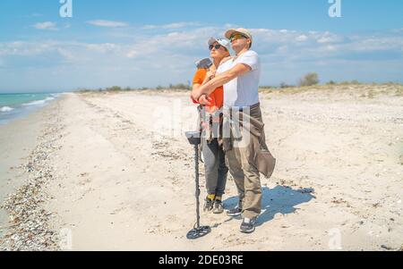 Coppia di adulti con metal detector sulla costa selvaggia del mare Foto Stock