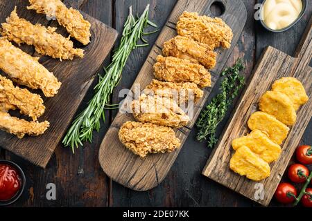 Pollo fritto impanato su fondo di legno scuro, piatto Foto Stock