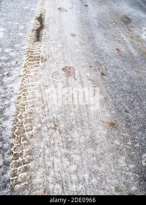 strada urbana coperta di ghiaccio scivolosa con pista dopo la pioggia ghiacciata il freddo giorno d'autunno Foto Stock
