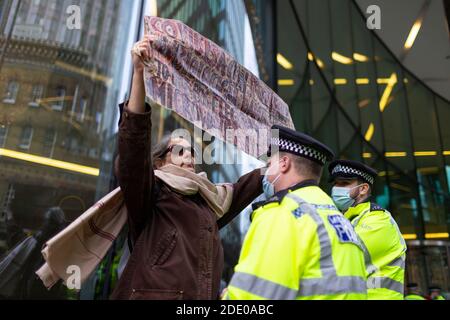 Il manifestante tiene un cartello davanti alla polizia durante la protesta contro la vaccinazione, Bill e Melinda Gates Foundation Office, Londra, 24 novembre 2020 Foto Stock