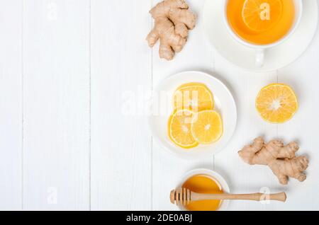 Zenzero con tè alle erbe al limonee su sfondo bianco di legno Foto Stock