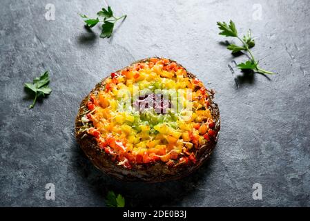 Arcobaleno veggie peperoni campana crosta pizza su fondo di pietra blu. Cibo vegetariano vegano o sano. Foto Stock