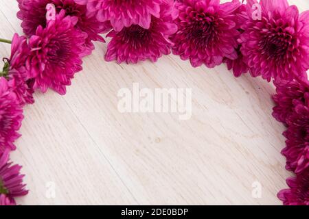 Fiori rosa in un cerchio su sfondo di legno Foto Stock