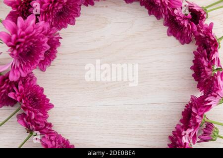 Fiori rosa in un cerchio su sfondo di legno Foto Stock