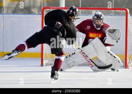 i giocatori di hockey dei giovani sparano su goalie durante l'hockey su ghiaccio all'aperto formazione Foto Stock