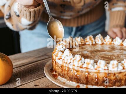 Processo di decorazione di Cheesecake Pumpkin - dessert del Ringraziamento Foto Stock