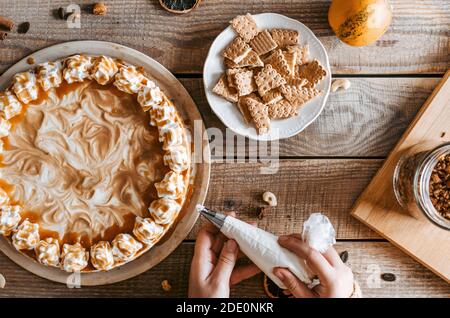 Processo di decorazione di Cheesecake Pumpkin - dessert del Ringraziamento Foto Stock