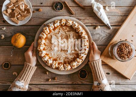 Un processo decorativo di Cheesecake di zucca - dessert del Ringraziamento Foto Stock