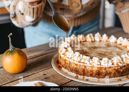 Processo di decorazione di Cheesecake Pumpkin - dessert del Ringraziamento Foto Stock