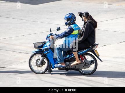 SAMUT PRAKAN, THAILANDIA, 27 2020 LUGLIO, UN tassista su una moto giri con una donna. Il conducente del mototaxi trasporta un passeggero. Foto Stock