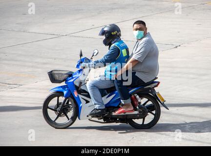 SAMUT PRAKAN, THAILANDIA, 27 2020 LUGLIO, UN tassista su una moto giri con un uomo con maschera. Foto Stock