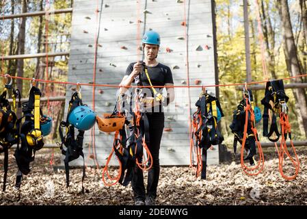 Bell'uomo che indossa attrezzature di sicurezza per l'arrampicata al parco divertimenti, preparandosi per l'arrampicata sulla parete Foto Stock