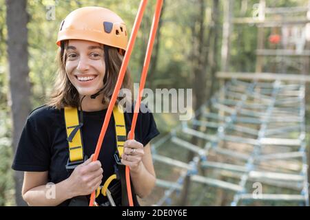 Ritratto di una giovane donna ben attrezzata che ha una ricreazione attiva in un parco di corda Foto Stock