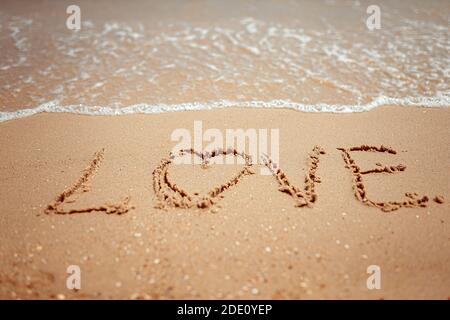 Parola d'amore manoscritta sulla Costa di sabbia. Parole meravigliose sulla spiaggia di sabbia. Concetto di idea di amore. Foto Stock