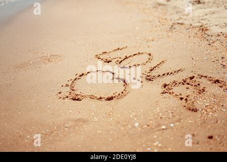 Parola d'amore manoscritta sulla Costa di sabbia. Parole meravigliose sulla spiaggia di sabbia. Concetto di idea di amore. Foto Stock