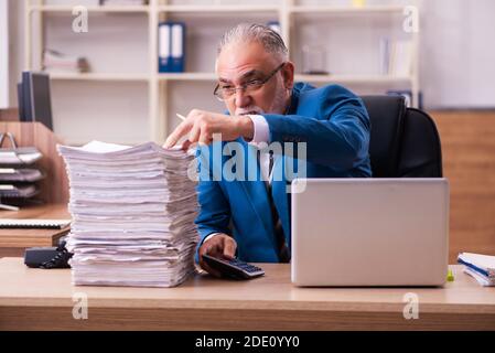 Il vecchio dipendente maschio è insoddisfatto del lavoro eccessivo sul posto di lavoro Foto Stock