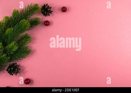 Composizione natalizia, semplice e con spazio copia, rami di abete, bacche rosse su uno sfondo luminoso e bello Foto Stock